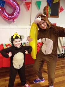 Small child in a monkey suit with women in Curious George monkey suit and inflatable banana at Spellbound Parties